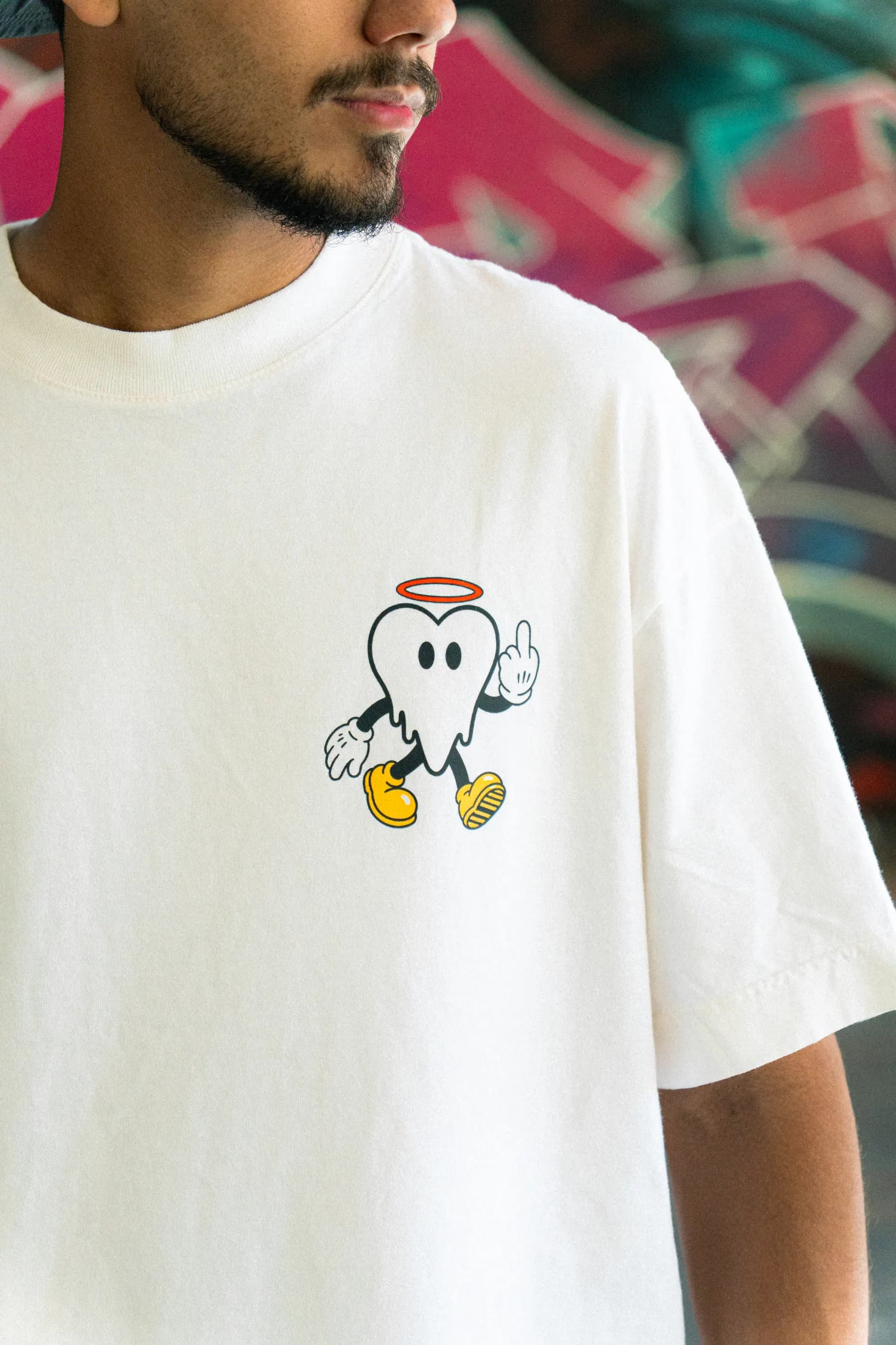 Detalhe do peito da camiseta off white com o mascote da L'OVER estampado.
